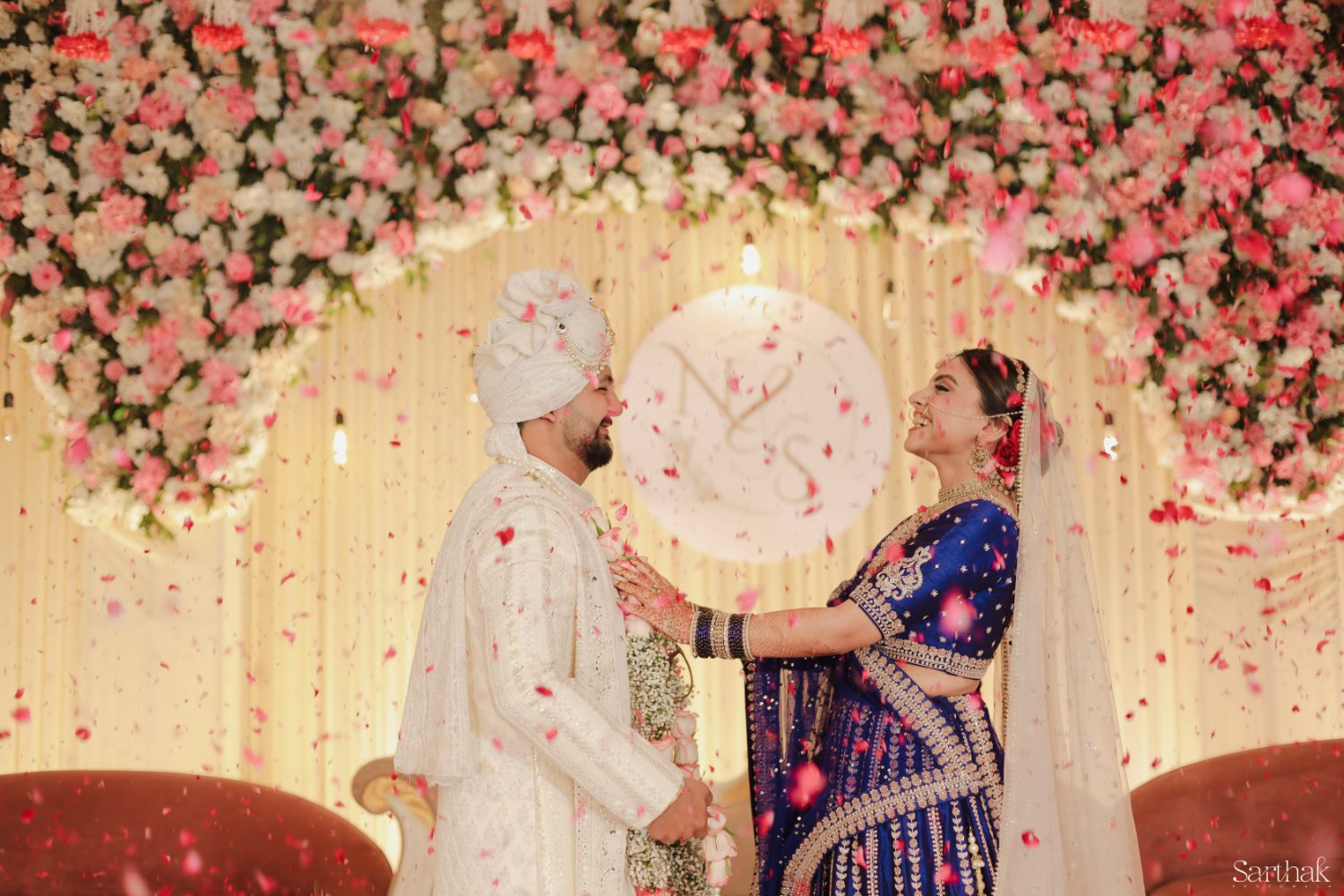 Bride and groom in a shower of petals at their reception