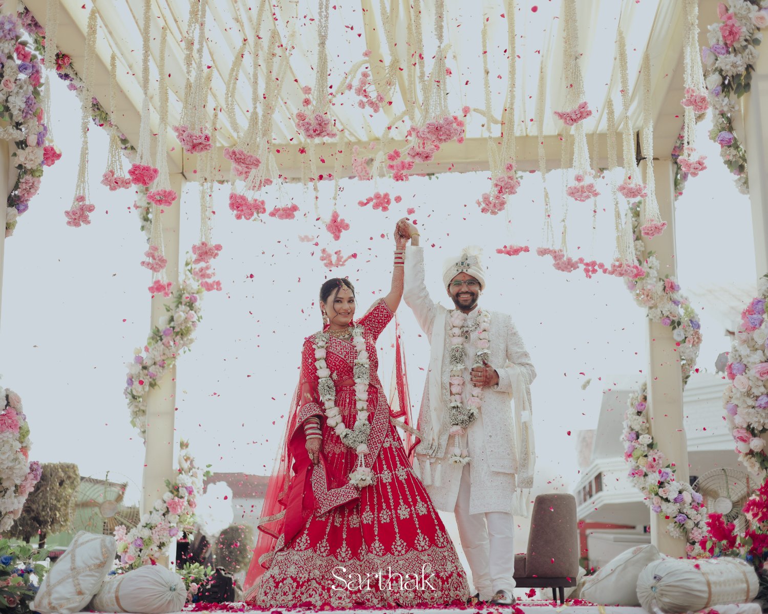 Couple celebrating under floral mandap